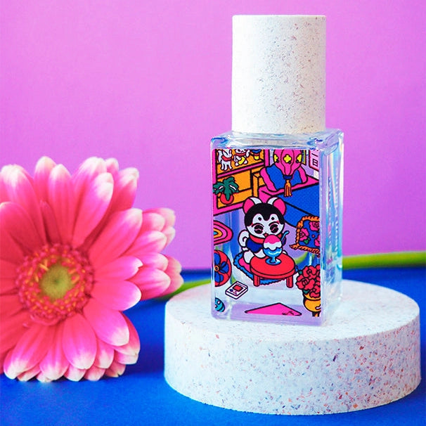 Small bottle with colorful label on a white stand against a purple background with a pink flower.